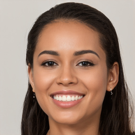 Joyful latino young-adult female with long  brown hair and brown eyes