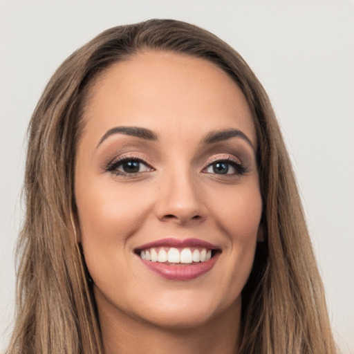 Joyful white young-adult female with long  brown hair and brown eyes