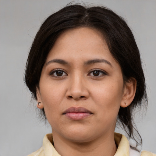 Joyful latino young-adult female with medium  brown hair and brown eyes