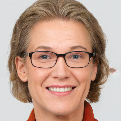 Joyful white middle-aged female with medium  brown hair and blue eyes