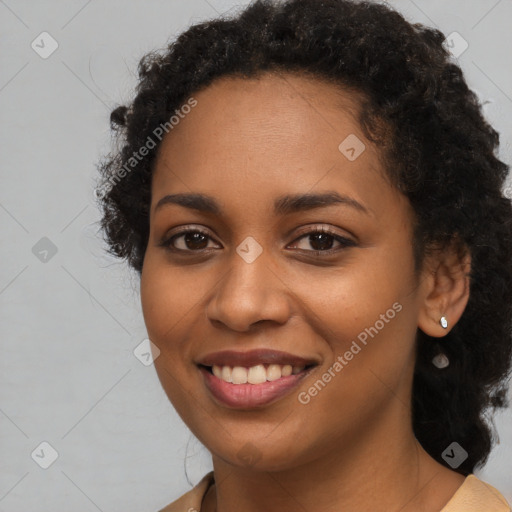 Joyful black young-adult female with long  black hair and brown eyes