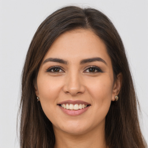 Joyful latino young-adult female with long  brown hair and brown eyes