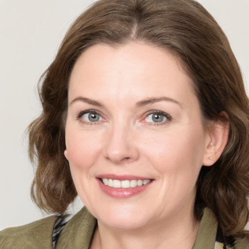 Joyful white adult female with medium  brown hair and grey eyes