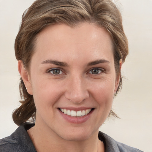 Joyful white young-adult female with medium  brown hair and grey eyes