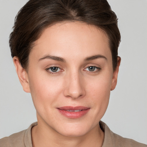 Joyful white young-adult female with short  brown hair and grey eyes