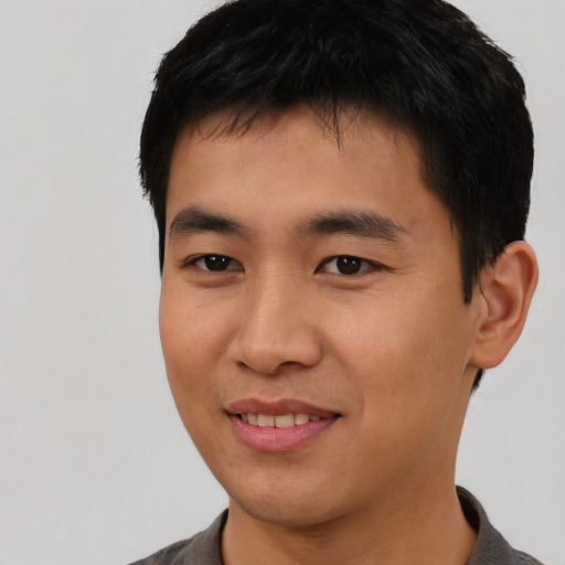 Joyful asian young-adult male with short  black hair and brown eyes