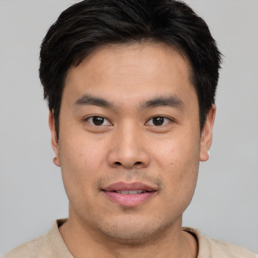 Joyful asian young-adult male with short  brown hair and brown eyes