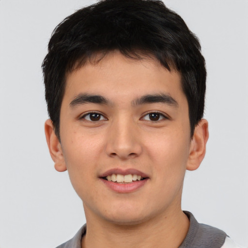 Joyful asian young-adult male with short  brown hair and brown eyes