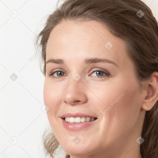 Joyful white young-adult female with medium  brown hair and blue eyes