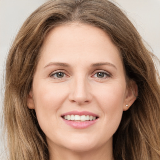 Joyful white young-adult female with long  brown hair and green eyes