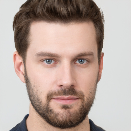 Joyful white young-adult male with short  brown hair and grey eyes