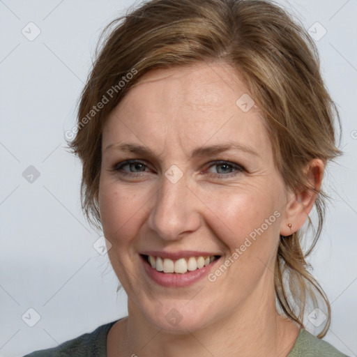 Joyful white adult female with medium  brown hair and grey eyes