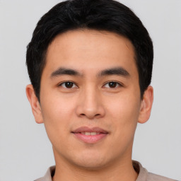 Joyful asian young-adult male with short  black hair and brown eyes