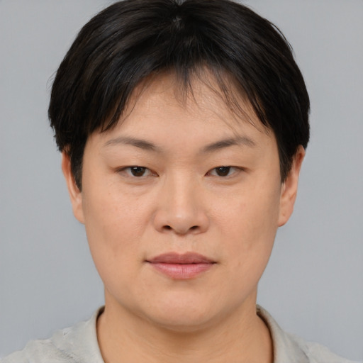 Joyful asian young-adult female with short  brown hair and brown eyes