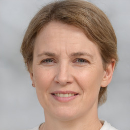 Joyful white adult female with medium  brown hair and grey eyes