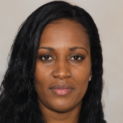 Joyful black young-adult female with long  black hair and brown eyes