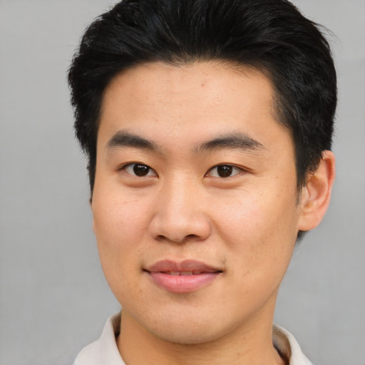 Joyful asian young-adult male with short  brown hair and brown eyes