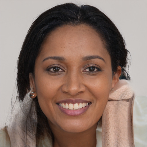Joyful black young-adult female with long  brown hair and brown eyes