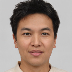 Joyful asian young-adult male with short  brown hair and brown eyes