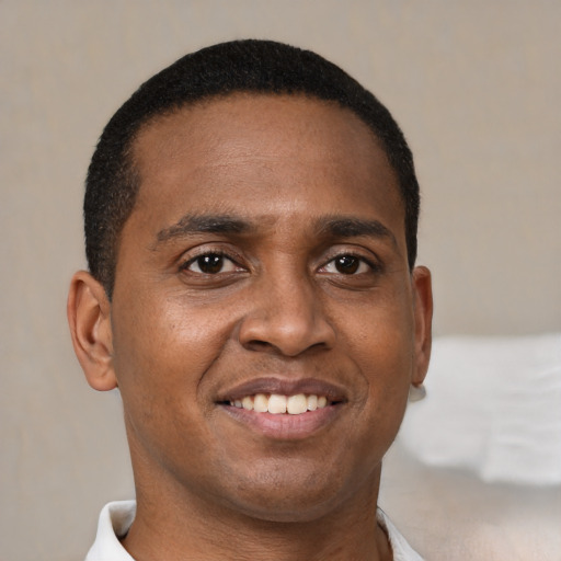 Joyful black young-adult male with short  brown hair and brown eyes