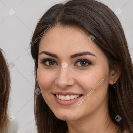 Joyful white young-adult female with long  brown hair and brown eyes