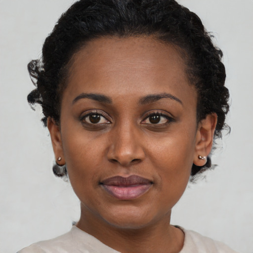 Joyful black young-adult female with short  brown hair and brown eyes