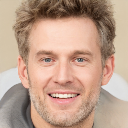 Joyful white adult male with short  brown hair and grey eyes