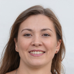 Joyful white young-adult female with long  brown hair and grey eyes