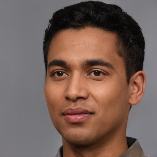 Joyful latino young-adult male with short  black hair and brown eyes