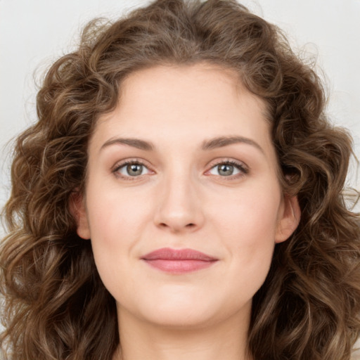 Joyful white young-adult female with long  brown hair and green eyes