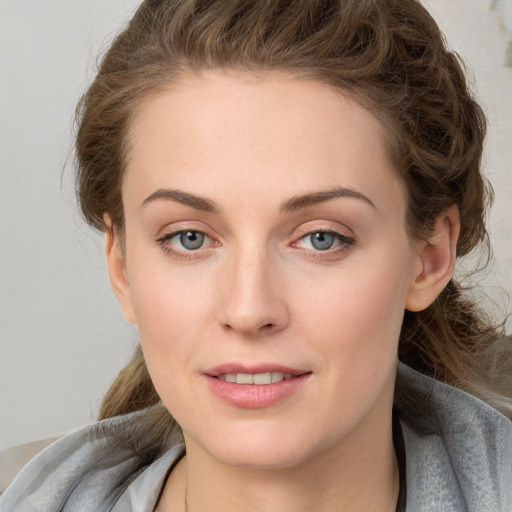 Joyful white young-adult female with medium  brown hair and blue eyes