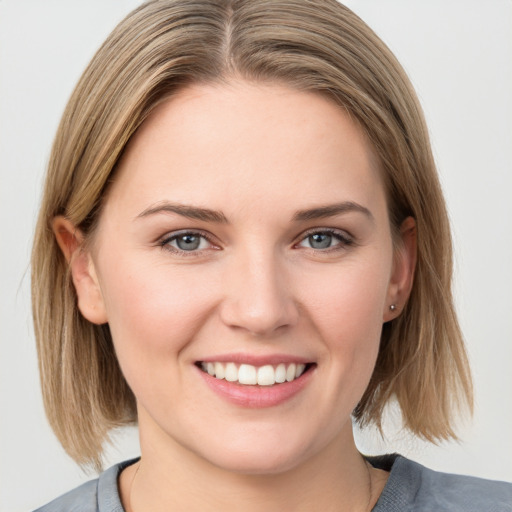 Joyful white young-adult female with medium  brown hair and blue eyes