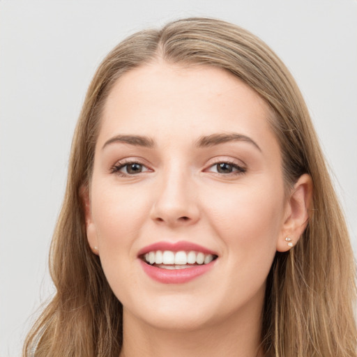 Joyful white young-adult female with long  brown hair and grey eyes