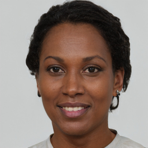 Joyful black adult female with short  black hair and brown eyes