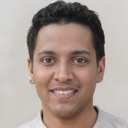 Joyful latino young-adult male with short  brown hair and brown eyes