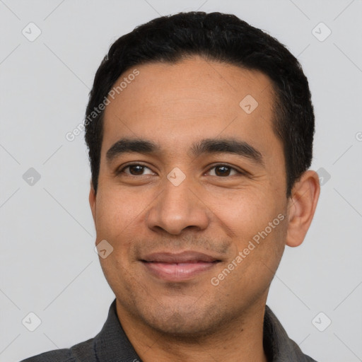 Joyful latino young-adult male with short  black hair and brown eyes