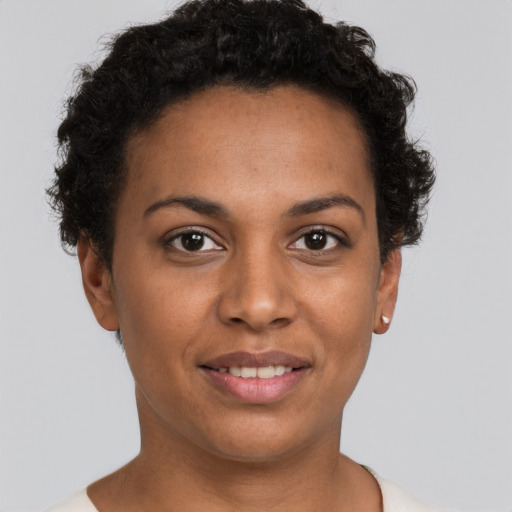 Joyful black young-adult female with short  brown hair and brown eyes