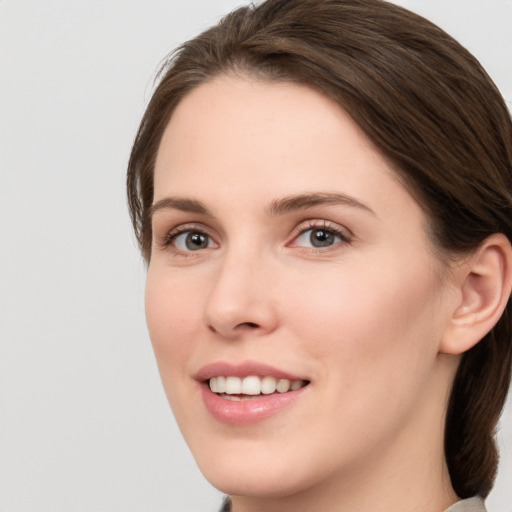 Joyful white young-adult female with medium  brown hair and grey eyes