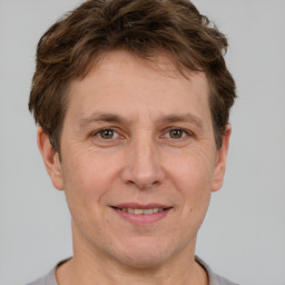 Joyful white adult male with short  brown hair and grey eyes