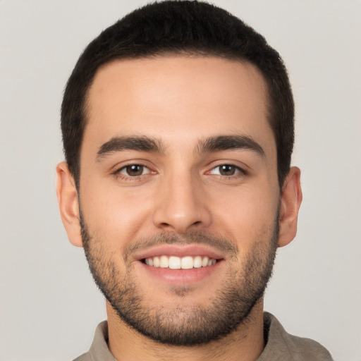 Joyful white young-adult male with short  black hair and brown eyes