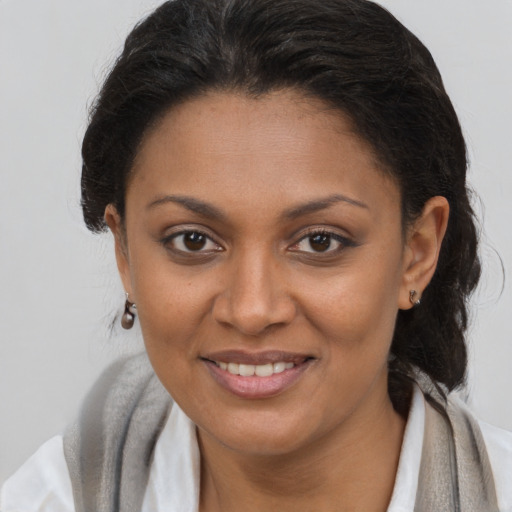 Joyful black young-adult female with long  brown hair and brown eyes