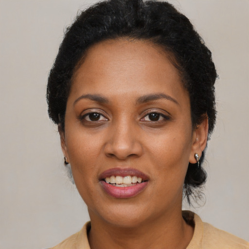 Joyful black adult female with short  black hair and brown eyes