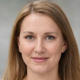 Joyful white adult female with long  brown hair and grey eyes