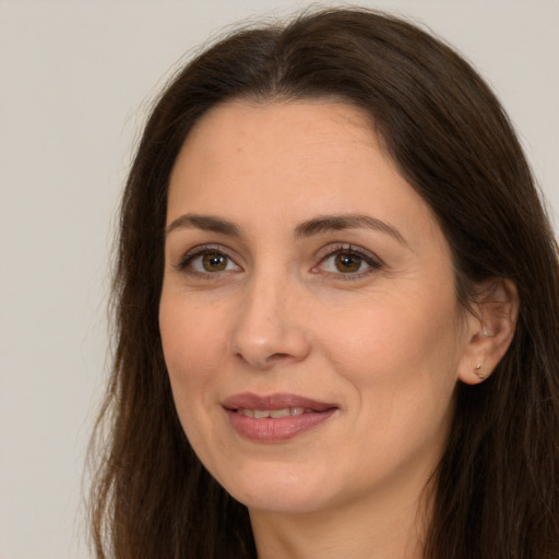 Joyful white adult female with long  brown hair and brown eyes