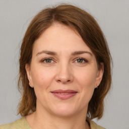 Joyful white adult female with medium  brown hair and grey eyes