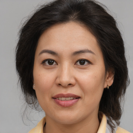 Joyful asian adult female with medium  brown hair and brown eyes