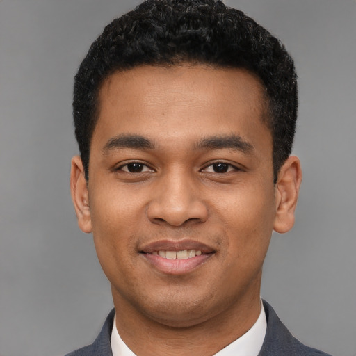 Joyful latino young-adult male with short  black hair and brown eyes