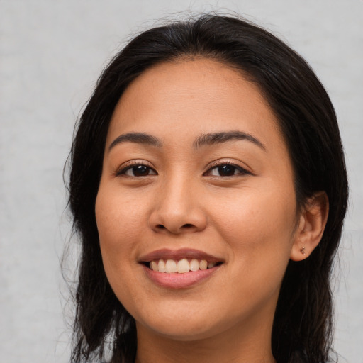 Joyful asian young-adult female with long  brown hair and brown eyes