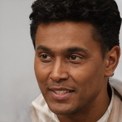 Joyful latino adult male with short  black hair and brown eyes