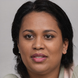 Joyful black adult female with medium  brown hair and brown eyes